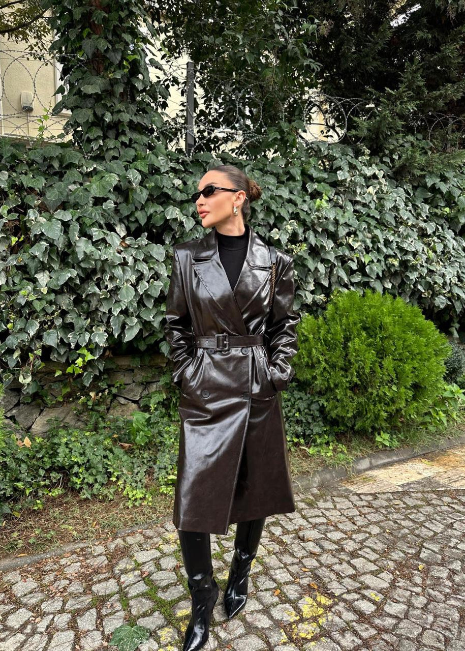 manteau trench femme, trench simili cuir, manteau long femme, trench marron foncé, mode femme hiver, veste mi-saison, élégance rock chic, trench coat, Stockholm.ma, vêtement femme, manteau tendance, simili cuir brillant, look urbain, chic intemporel, trench cuir vegan.
