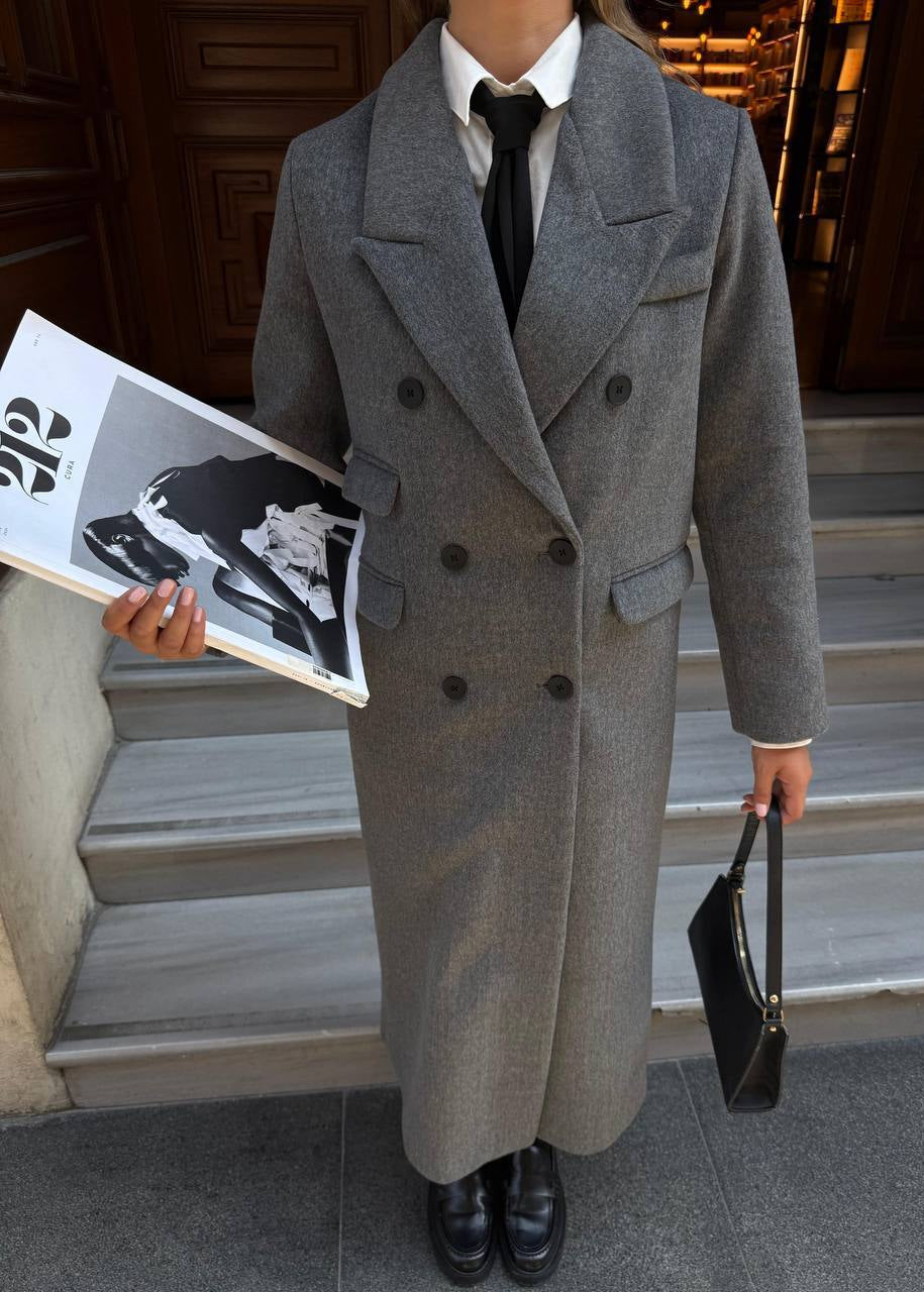 manteau long femme, manteau laine grise, manteau droit femme, manteau hiver femme, élégance minimaliste, manteau double boutonnage, mode femme hiver, Stockholm.ma, vêtement femme, manteau classique, gris chiné, look urbain chic, chic intemporel, manteau automne femme.