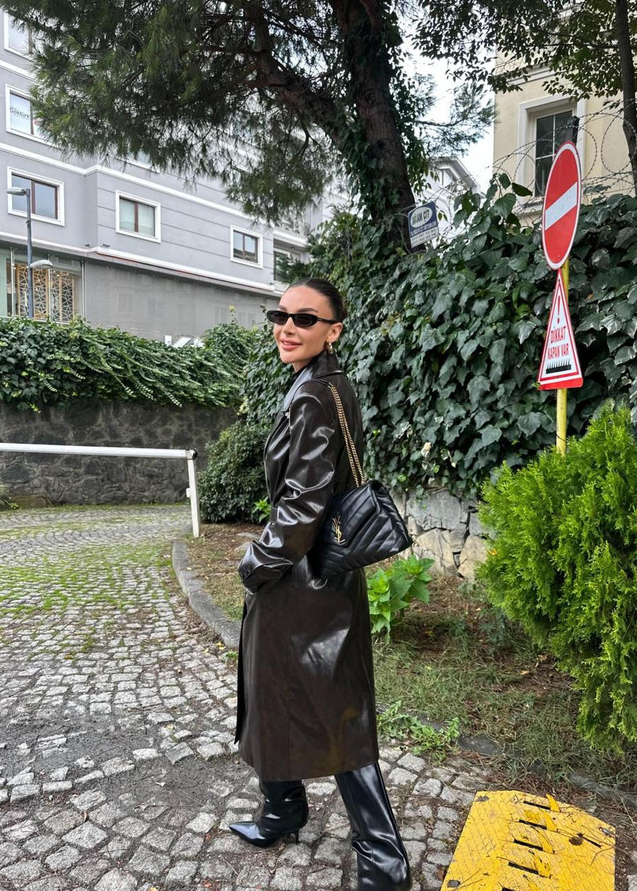 manteau trench femme, trench simili cuir, manteau long femme, trench marron foncé, mode femme hiver, veste mi-saison, élégance rock chic, trench coat, Stockholm.ma, vêtement femme, manteau tendance, simili cuir brillant, look urbain, chic intemporel, trench cuir vegan.