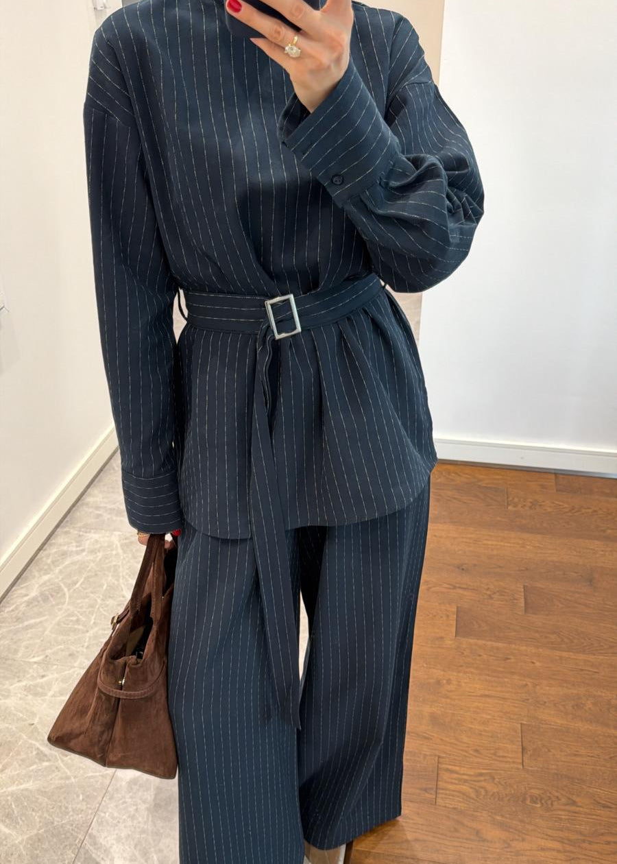 Marque/Produit : Ensemble femme, deux pièces femme, tailleur pantalon fluide, blouse longue et pantalon, ensemble rayé, pinstripe femme, ensemble noir/bleu marine.
Style/Esthétique : Chic, élégant, sophistiqué, moderne, tendance, professionnel, business, décontracté chic, androgyne.
Couleur/Motif : Noir, bleu marine foncé, rayures fines, pinstripe, ligné.
Caractéristiques : Blouse longue, col montant/semi-montant, ceinture à boucle, pantalon large, coupe palazzo, tissu fluide, manches longues.
Matière (supp