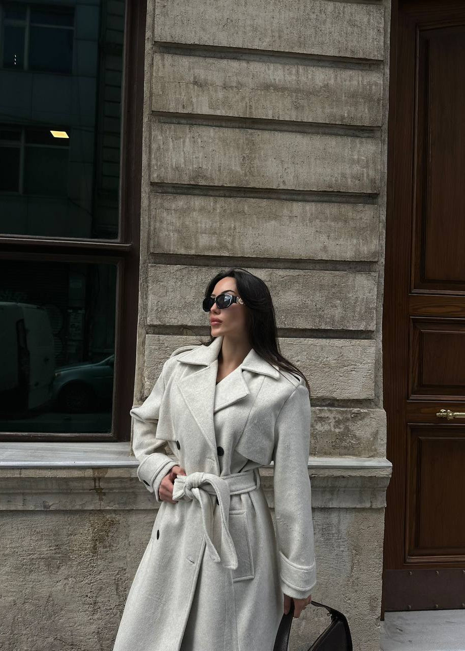  manteau trench femme, trench laine écru, manteau long femme, trench beige clair, élégance lumineuse, manteau double boutonnage, mode femme printemps, Stockholm.ma, vêtement femme luxe, manteau classique, couleur écru, look casual chic, chic sophistiqué, trench mi-saison, manteau automne femme.