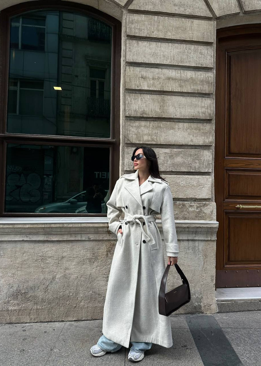  manteau trench femme, trench laine écru, manteau long femme, trench beige clair, élégance lumineuse, manteau double boutonnage, mode femme printemps, Stockholm.ma, vêtement femme luxe, manteau classique, couleur écru, look casual chic, chic sophistiqué, trench mi-saison, manteau automne femme.